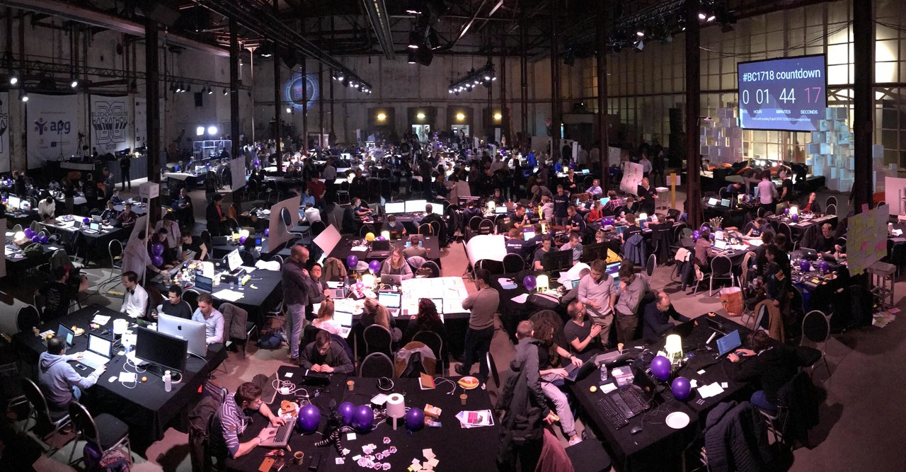 Blockchain Hackathon in Groningen in 2018 - a hall full of people around tables with computers